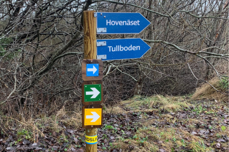 Vägvisare på vandringsled. Pekar mot Tullboden och Hovenäset