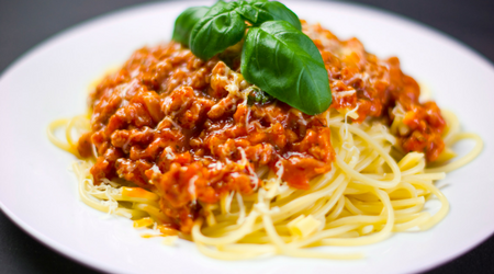 Spaghetti och köttfärssås med basilikablad.