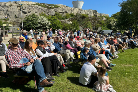 stor publik sitter framför vattentornet på Smögen och tittar mot scen