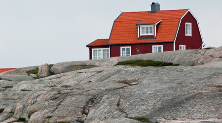 Rött hus på granitberg.