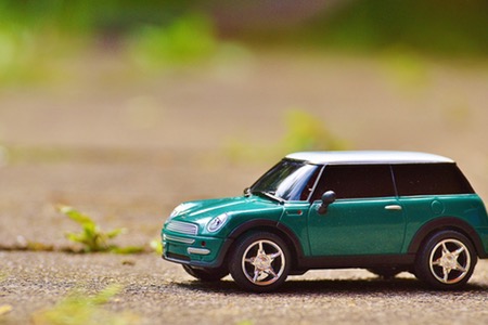 Grön leksaksbil som står på asfalt.